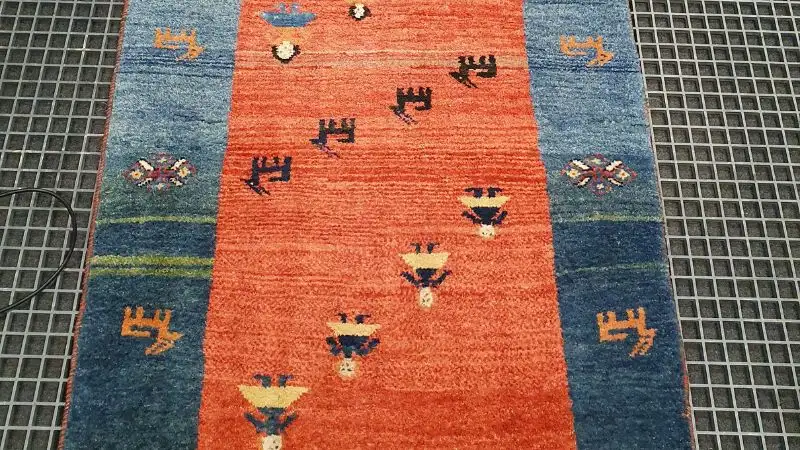 A gabbeh wool rug laid out following the cleaning process.